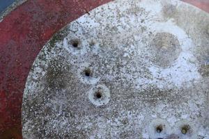 detaljerad närbild av kulhål från pistolskott i en trafikskylt foto
