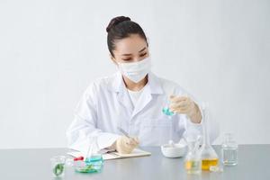 läkare kvinna forskare framställning ört- medicin i labb med ört löv vitamin tillskott mineral alternativ behandling forskning. foto