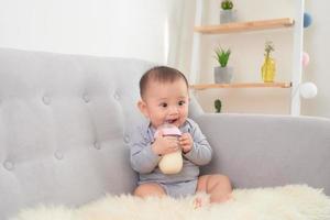 Asien bebis flicka matning med mjölk flaska foto