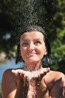 skön kvinna tvättning och rengöring ansikte under dusch foto