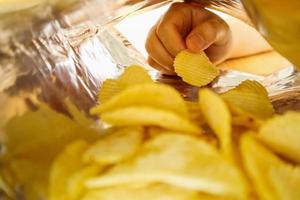 handhåll potatischips inuti snack foliepåse foto