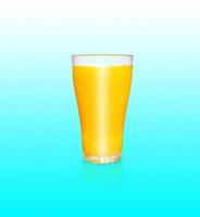 en glas av orange juice innehåller orange massa. med de reflexion av en glas av orange juice på en blå bakgrund foto