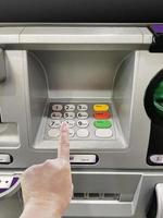en mannens hand är handla om till stiga på en koda på ett bankomat numerisk knappsats foto