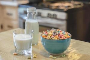 skål av färgrik barns flingor och mjölk isolerat på trä tabell med text Plats foto
