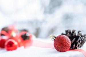 jul av vinter- - jul bollar med band på snö, vinter- högtider begrepp. jul röd bollar, gyllene bollar, tall och snöflingor dekorationer i snö bakgrund foto