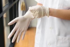 läkare som sätter handskar foto