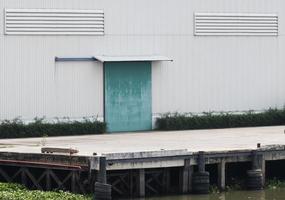 vit lager byggnad med grön dörr på hamn foto