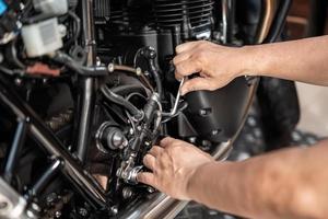 mekaniker använder sig av en hex nyckel eller allen rycka till ta bort motorcykel bak- hydraulisk broms pump, arbetssätt i garage .underhåll och reparera motorcykel begrepp .selektiv fokus foto
