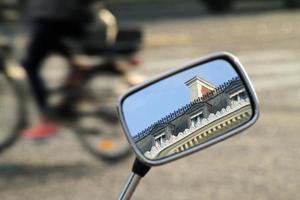 pendlare på en cykel går över en moped i paris, Frankrike foto