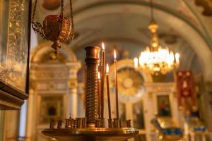 ortodox kyrka. kristendomen. festlig inredning med brinnande ljus och ikon i traditionell ortodox kyrka på påskafton eller jul. religion tro ber symbol. foto