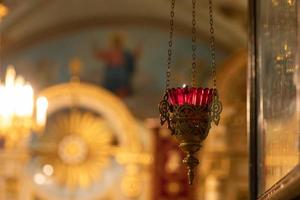 ortodox kyrka. kristendomen. festlig inredning med brinnande ljus och ikon i traditionell ortodox kyrka på påskafton eller jul. religion tro ber symbol. foto