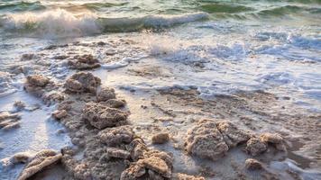 kristallin salt på Strand av död- hav på solnedgång foto