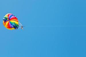kvinna parakitering på fallskärm i blå himmel foto