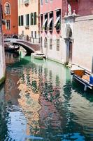 kanal, båtar och bro i Venedig, Italien foto