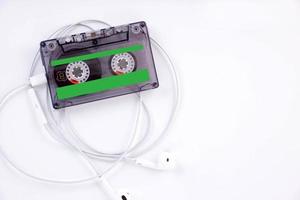 audio kassett med hörlurar, lögner på en ljus bakgrund. kopia Plats foto