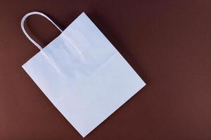 tom hantverk väska mockup, attrapp av vit papper handla väska med handtag på mörk bakgrund. foto