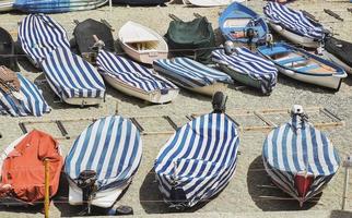 små fiske båtar av liguria med omslag och förtöjd i de strand foto