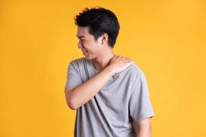 asiatisk ung man Framställ på en gul bakgrund foto