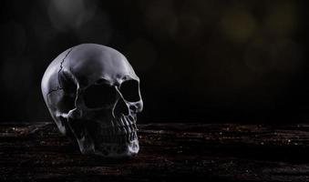 halloween mänsklig skalle på ett gammal trä- tabell över svart bakgrund. form av skalle ben för död huvud på halloween festival som visa Skräck ondska tand rädsla och skrämmande med dimma rök, kopia Plats foto