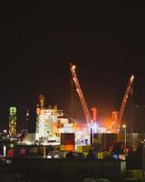 läser in frakt fartyg i batumi hav hamn sent på natt arbete i mörker. importera exportera kaukasus företag industriell zon foto