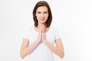 koncentrerad brunett kvinna i t skjorta bön- med be gest isolerat på vit bakgrund foto