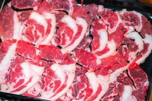 glida rå nötkött för yakiniku. tunn bit nötkött för shabu köttgryta japansk mat stil. stänga upp färsk kött kasta öga för sukiyaki. topp se foto