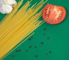 spaghetti, vitlök och halv en tomat. foto