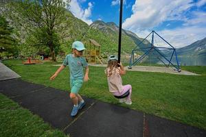 bror med syster svängande i lekplats på hallstatt, Österrike. foto