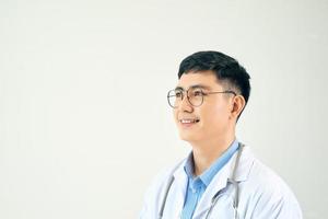 vuxen forskare eller läkare man bär vit täcka över isolerat bakgrund ser bort till sida med leende på ansikte foto