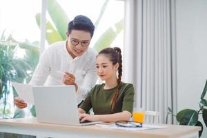 två ung företag kollegor arbetssätt med bärbar dator på kontor foto
