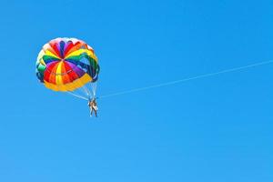 människor parascending på fallskärm i blå himmel foto