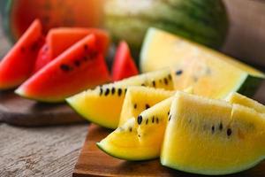 närbild ljuv vattenmelon skivor bitar färsk vattenmelon tropisk sommar frukt, röd och gul vattenmelon skiva på trä- skärande styrelse foto