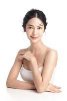 asiatisk kvinna med en skön ansikte och perfekt rena färsk hud. söt kvinna modell med naturlig smink och gnistrande ögon på vit isolerat bakgrund. ansiktsbehandling behandling, kosmetologi, skönhet begrepp. foto
