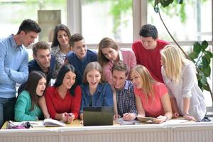 Lycklig tonåren grupp i skola foto