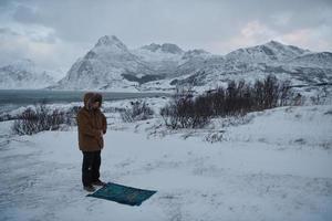 muslimsk resenär som ber i kall snöig vinterdag foto