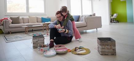 mor och liten flicka dotter spelar med Smycken på Hem foto