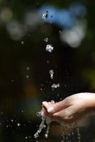 vatten ström på kvinna hand foto