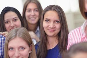 Lycklig tonåren grupp i skola foto