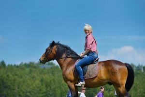 Lycklig kvinna rida häst foto