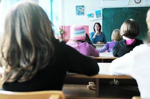 Lycklig lärare i skola klassrum foto