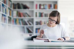 kvinna studerande studie i skola bibliotek foto