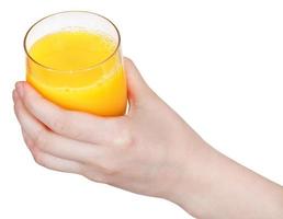 glas med orange juice i hand isolerat foto
