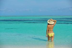 asiatisk kvinna vilar på sand på strand foto