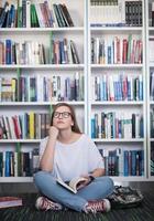 famale studerande läsning bok i bibliotek foto