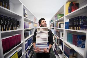 studerande innehav massa av böcker i skola bibliotek foto