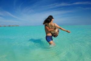 Lycklig ung par njuter sommar på strand foto