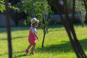 liten flicka springer i sommarparken foto