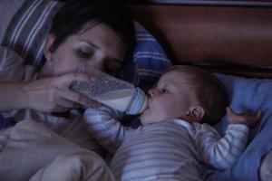 bebis äter mjölk från flaska foto