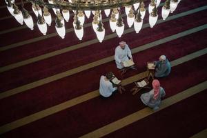 muslim människor i moské läsning quran tillsammans foto