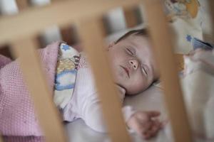 nyfödd bebis sovande på Hem i säng foto